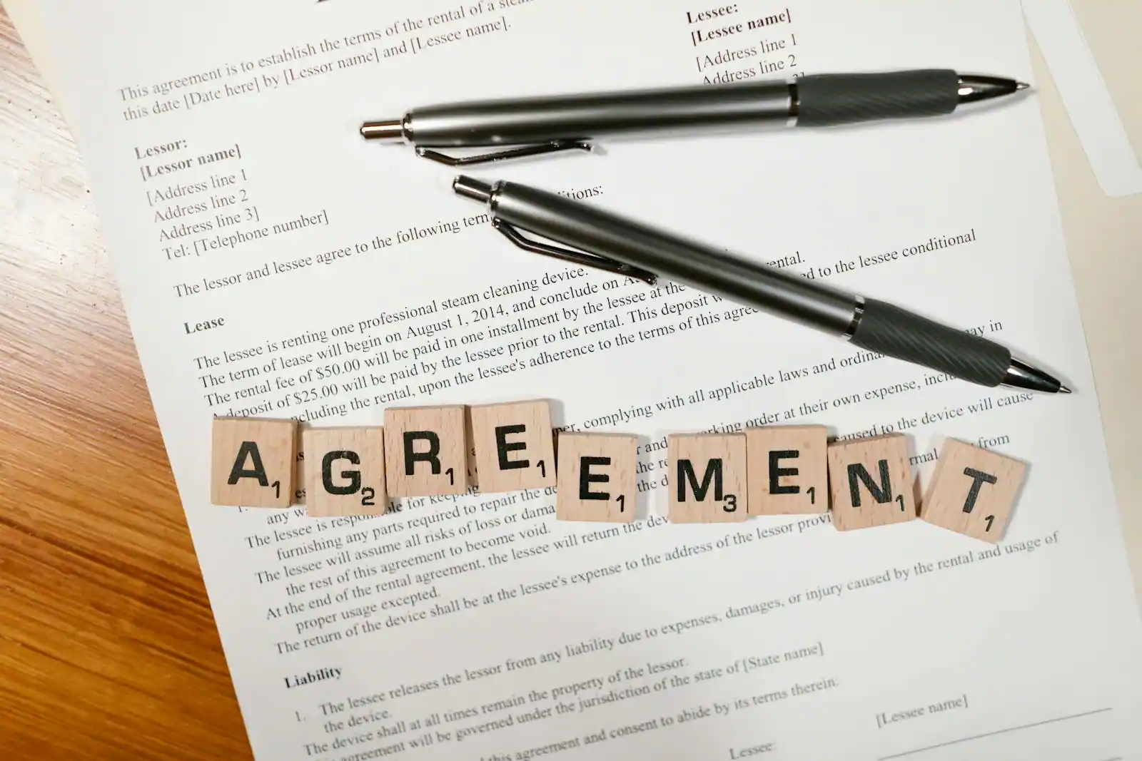 Propriétaire et locataire se serrant la main lors de la remise des clés d'un appartement, contrat de location posé sur une table