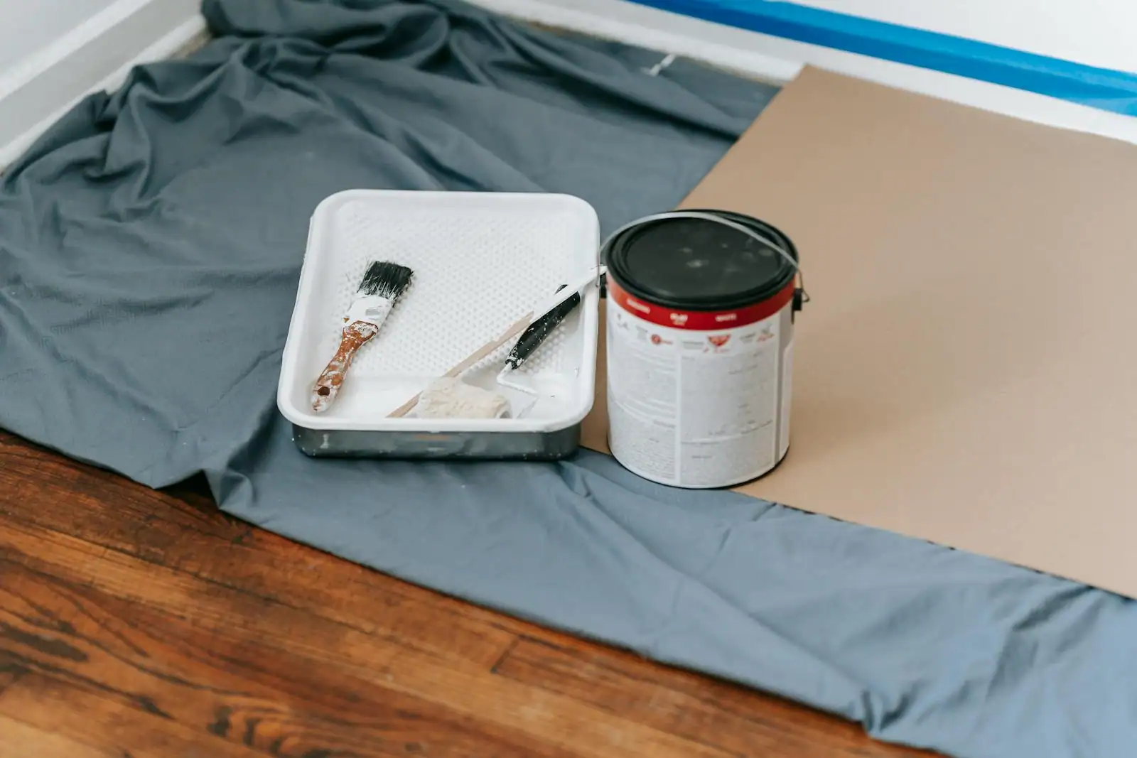 Porte intérieure en bois en cours de rénovation avec pinceau et pot de peinture