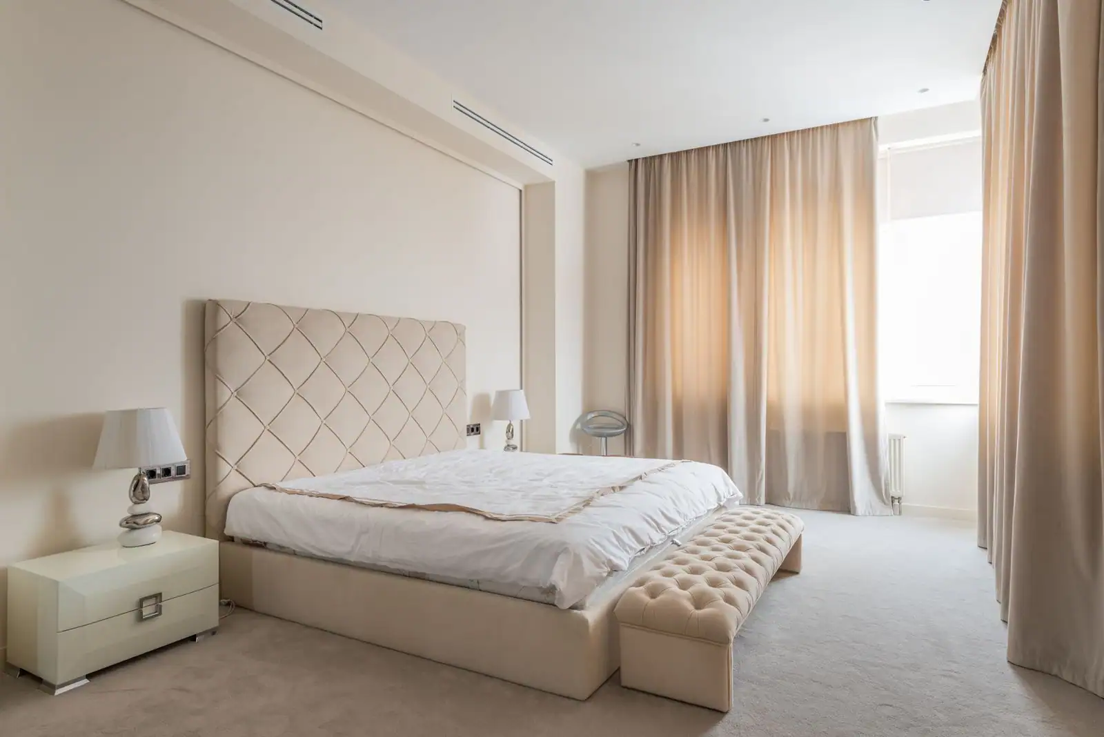 Chambre cosy avec une tête de lit capitonnée et deux chevets symétriques