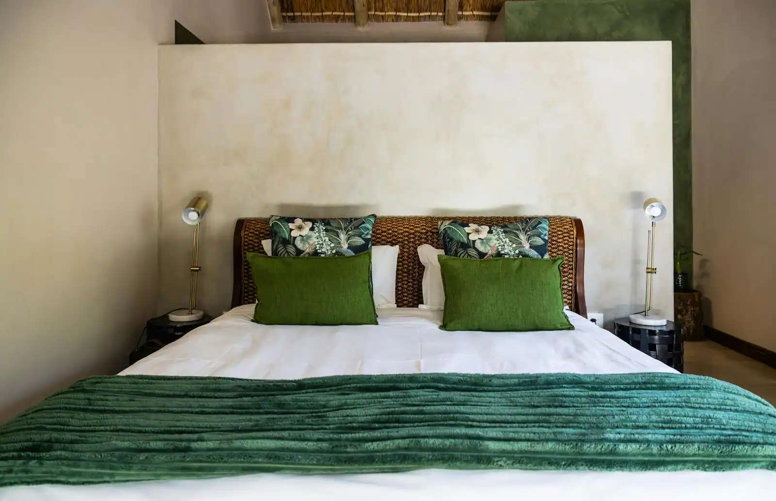 Tête de lit en rotin tressé dans une chambre lumineuse aux tons clairs et naturels