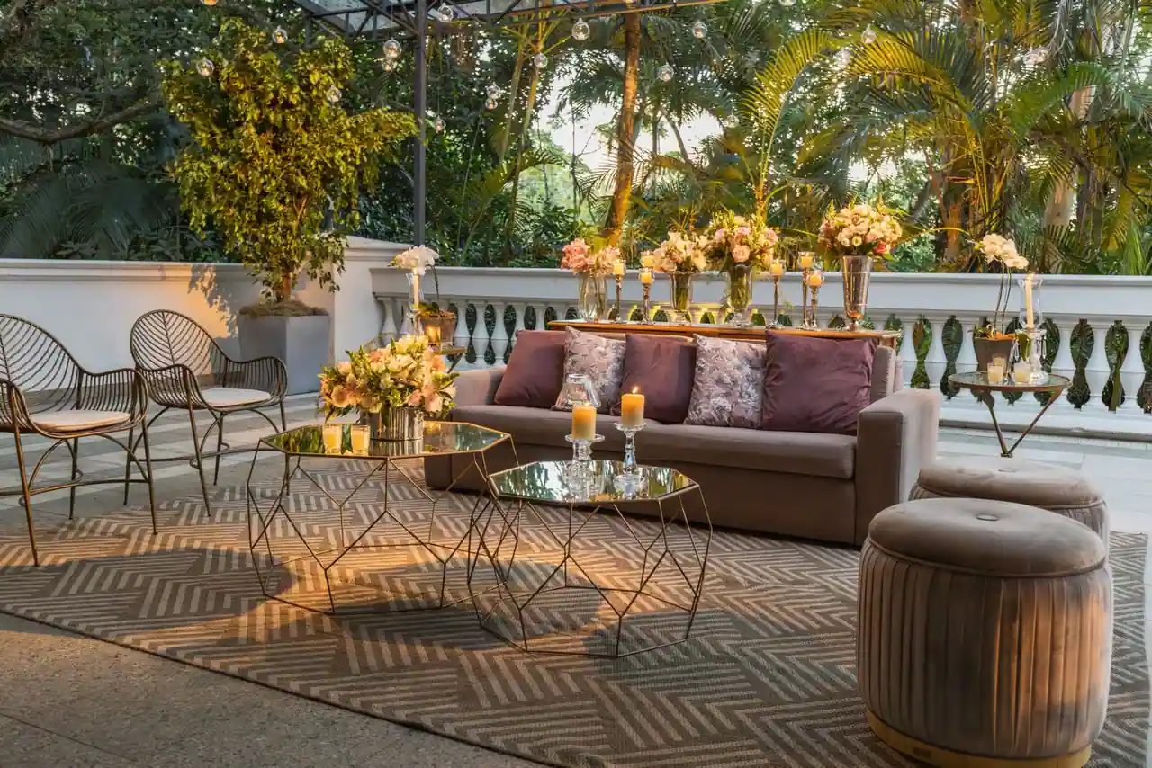 Terrasse extérieure aménagée avec salon de jardin, plantes en pot et coin repas à l'ombre