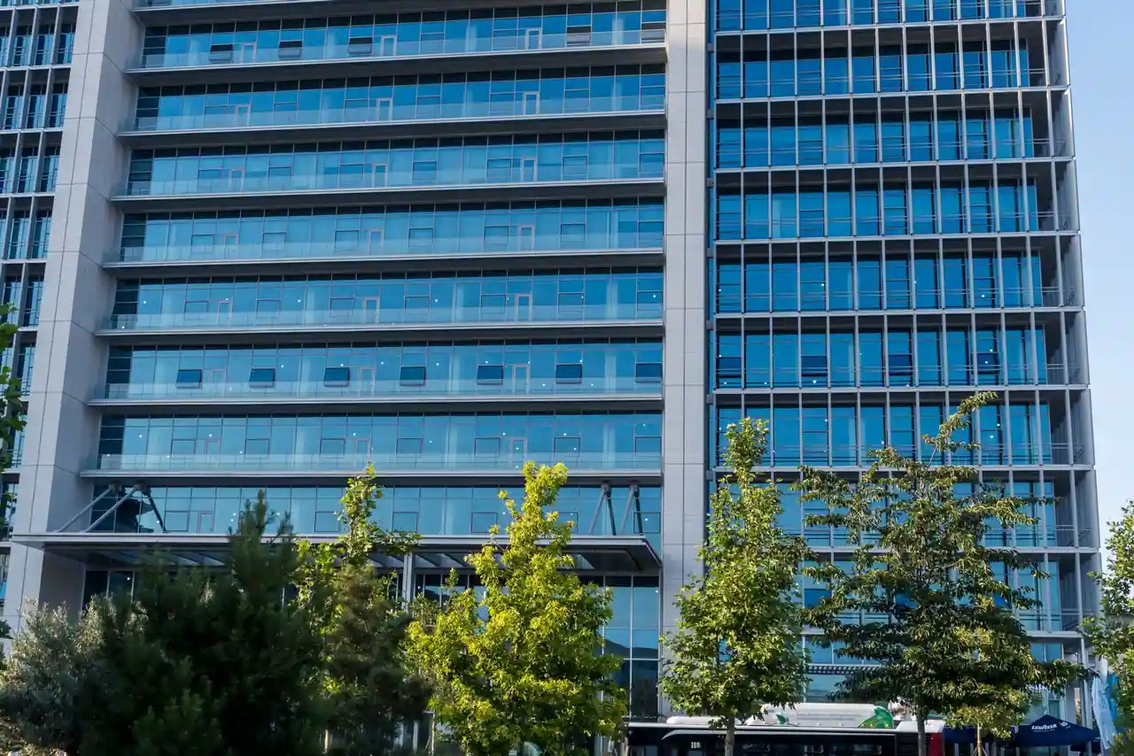 Façade vitrée d'un immeuble de bureaux dans un quartier d'affaires, illustrant le monde de l'entreprise