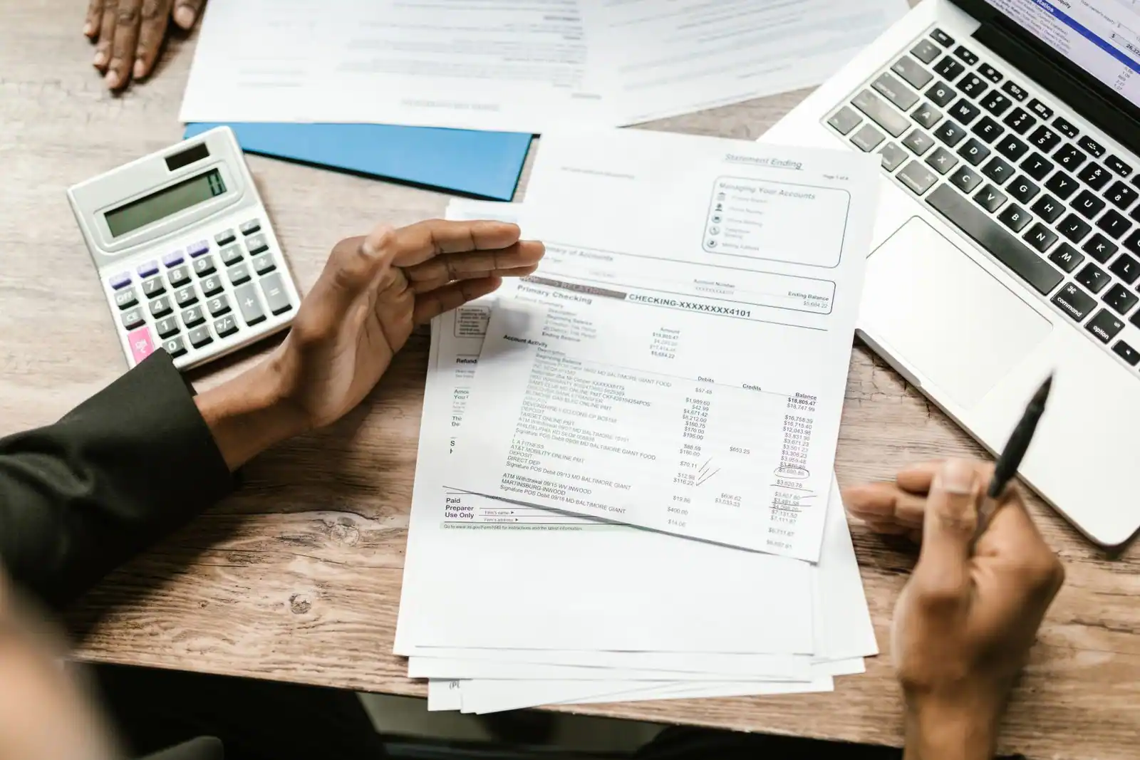 Documents financiers et calculatrice lors d'un examen des comptes — image illustrative