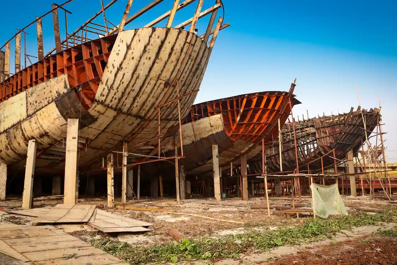 Coques de navires en bois en cours de construction sur cale dans un chantier naval traditionnel