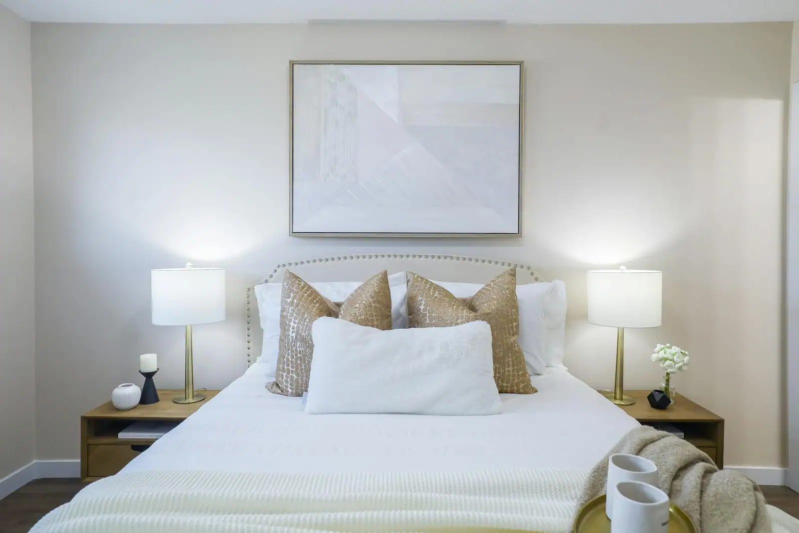 Chambre décorée aux tons doux avec lit habillé de linge clair et coussins