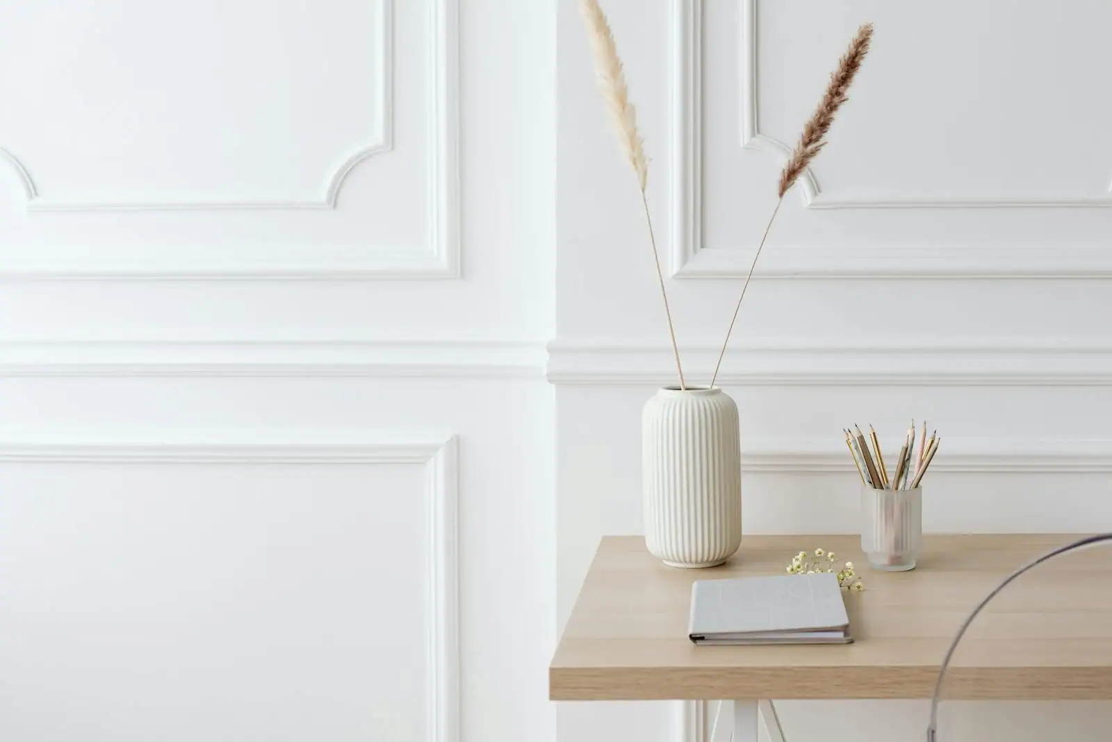 Bureau épuré et apaisant avec une plante verte, du bois clair et une lumière naturelle douce.