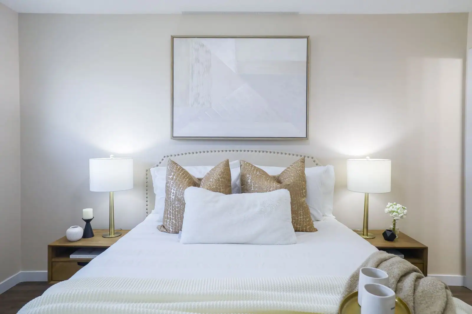 Chambre décorée aux tons neutres et doux, lit soigné avec tête de lit et linge en lin.