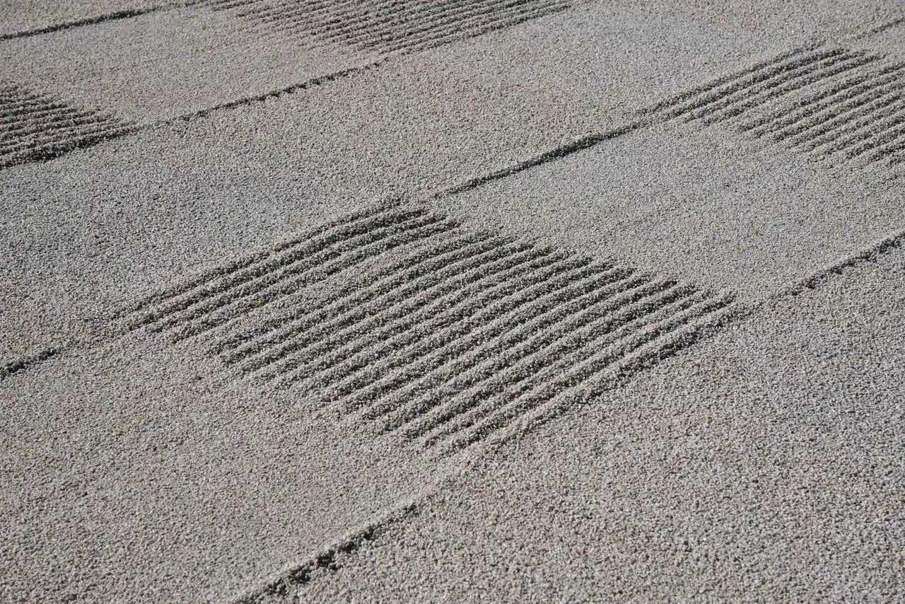 Gravier clair d'un jardin zen ratissé en motifs géométriques