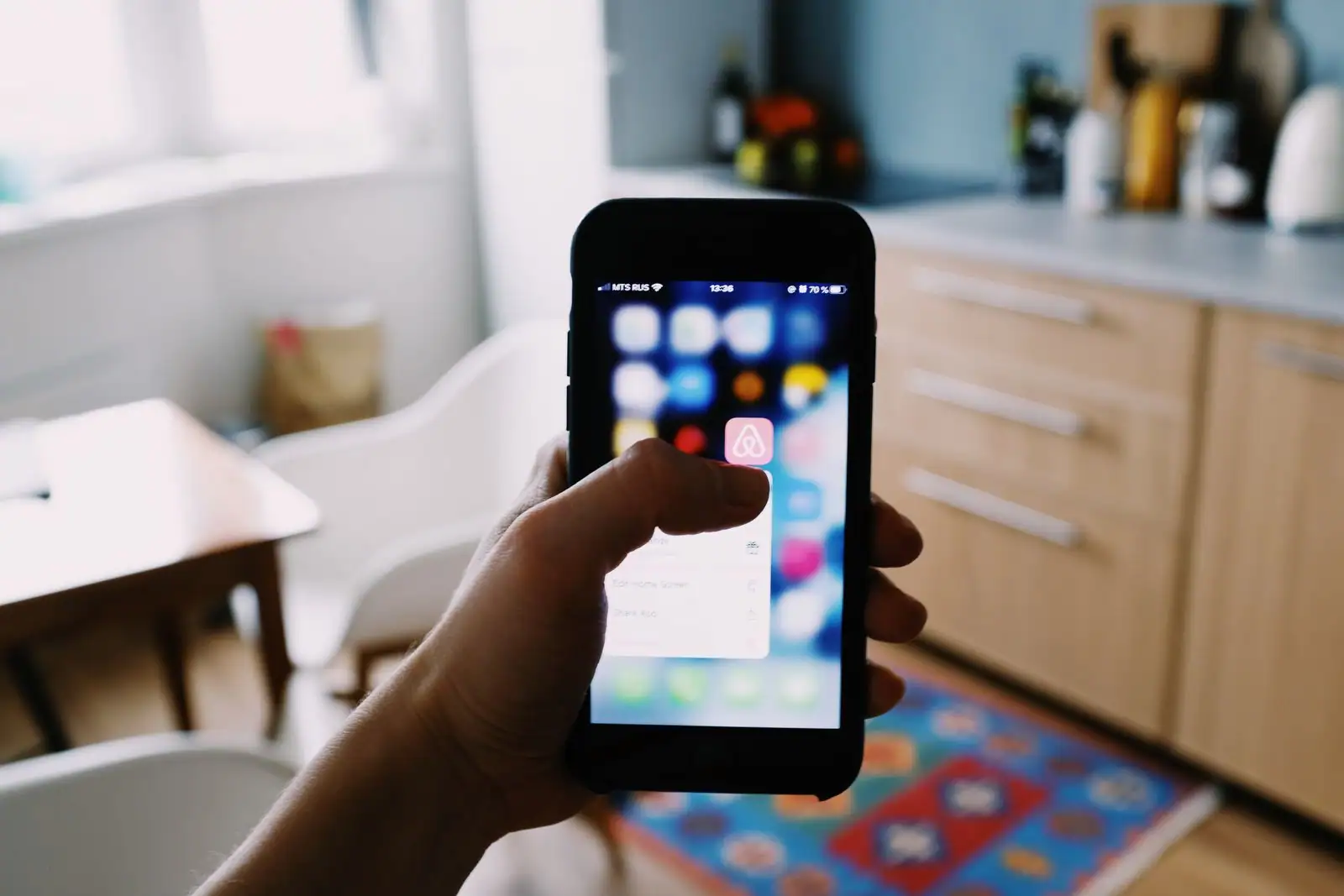 Personne consultant des annonces de location sur une carte géolocalisée depuis son smartphone