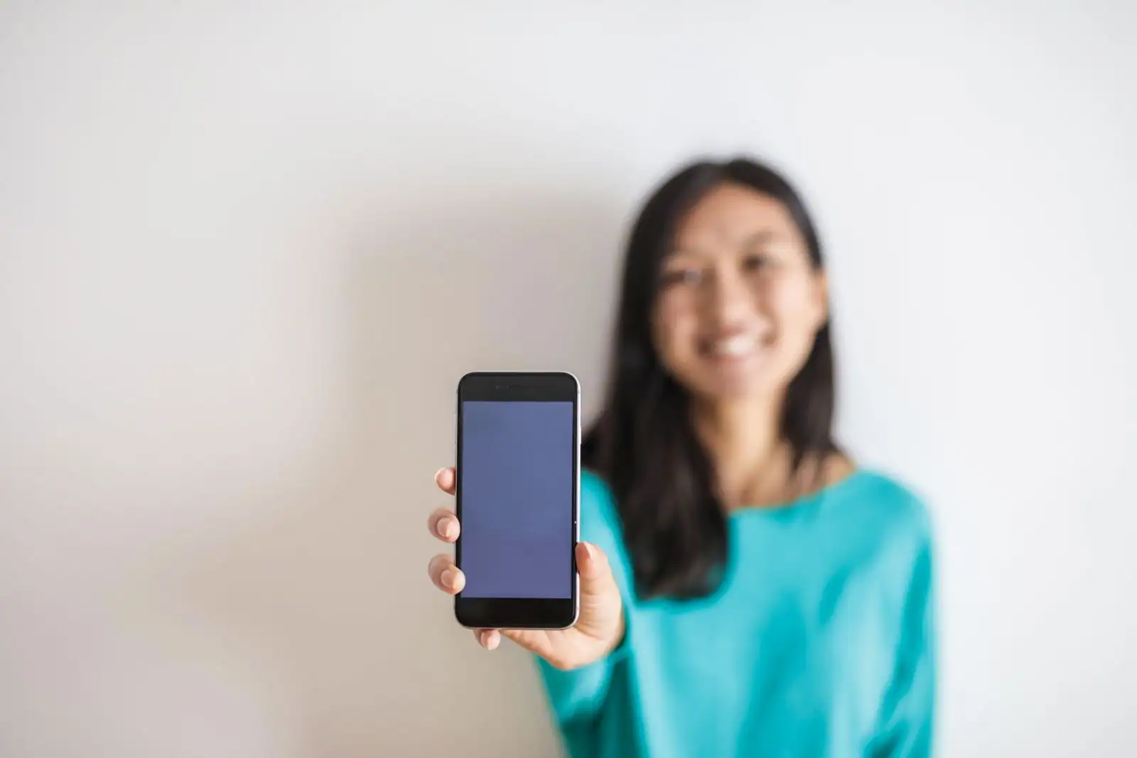 Personne tenant un smartphone moderne à la main, évoquant la location d'un téléphone mobile