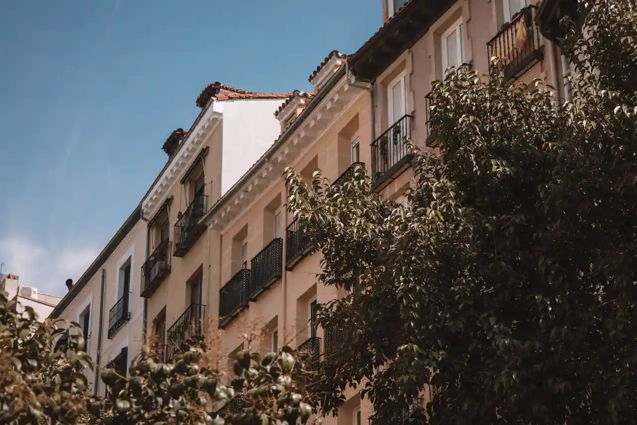 Façade d'immeuble résidentiel espagnol aux balcons en fer forgé, sous un ciel bleu