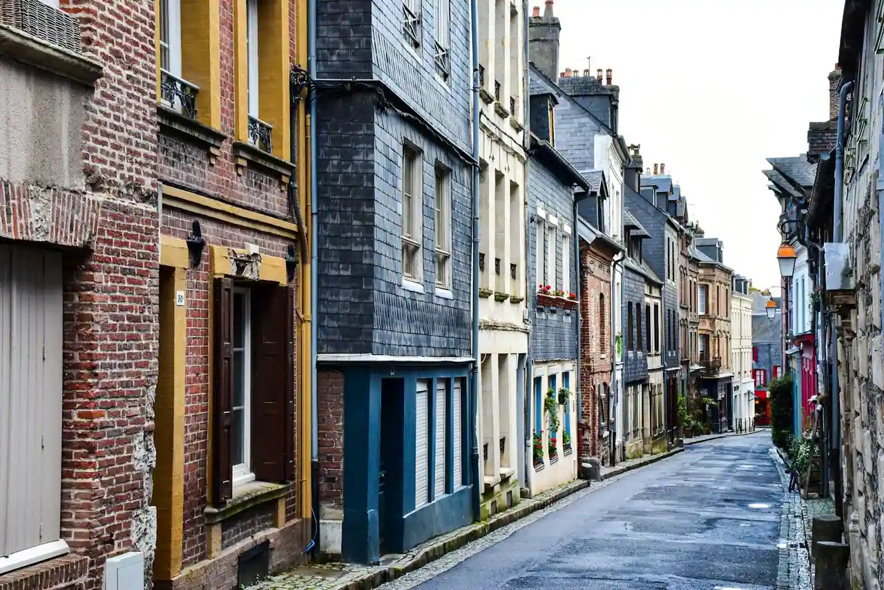 Rue résidentielle française bordée d'immeubles et de maisons individuelles, illustrant un marché immobilier local.