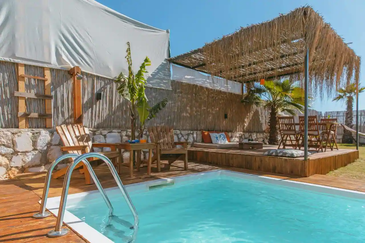 Salon de jardin en résine tressée et aluminium installé au bord d'une piscine