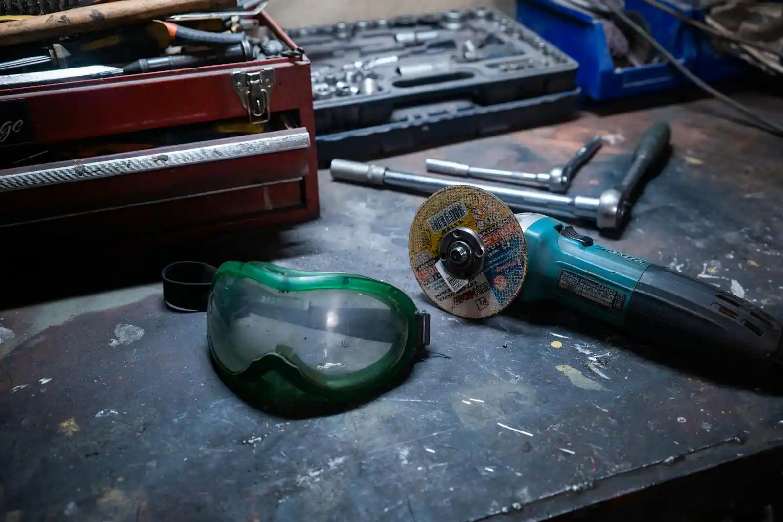Outils électroportatifs professionnels, perceuse et meuleuse, posés sur l'établi d'un atelier.
