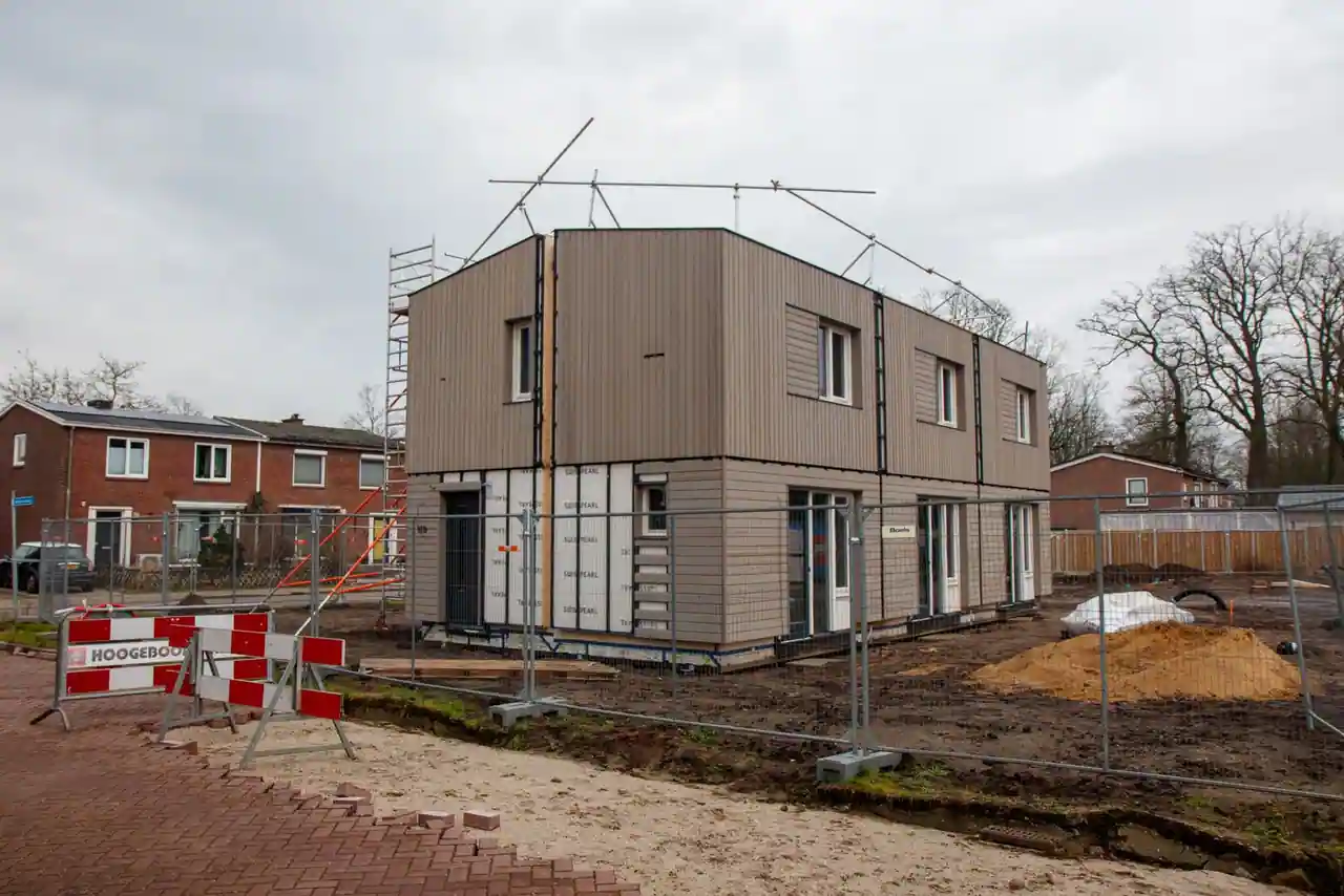 Maison individuelle moderne en cours de construction, échafaudage et barrières de chantier autour du bâtiment