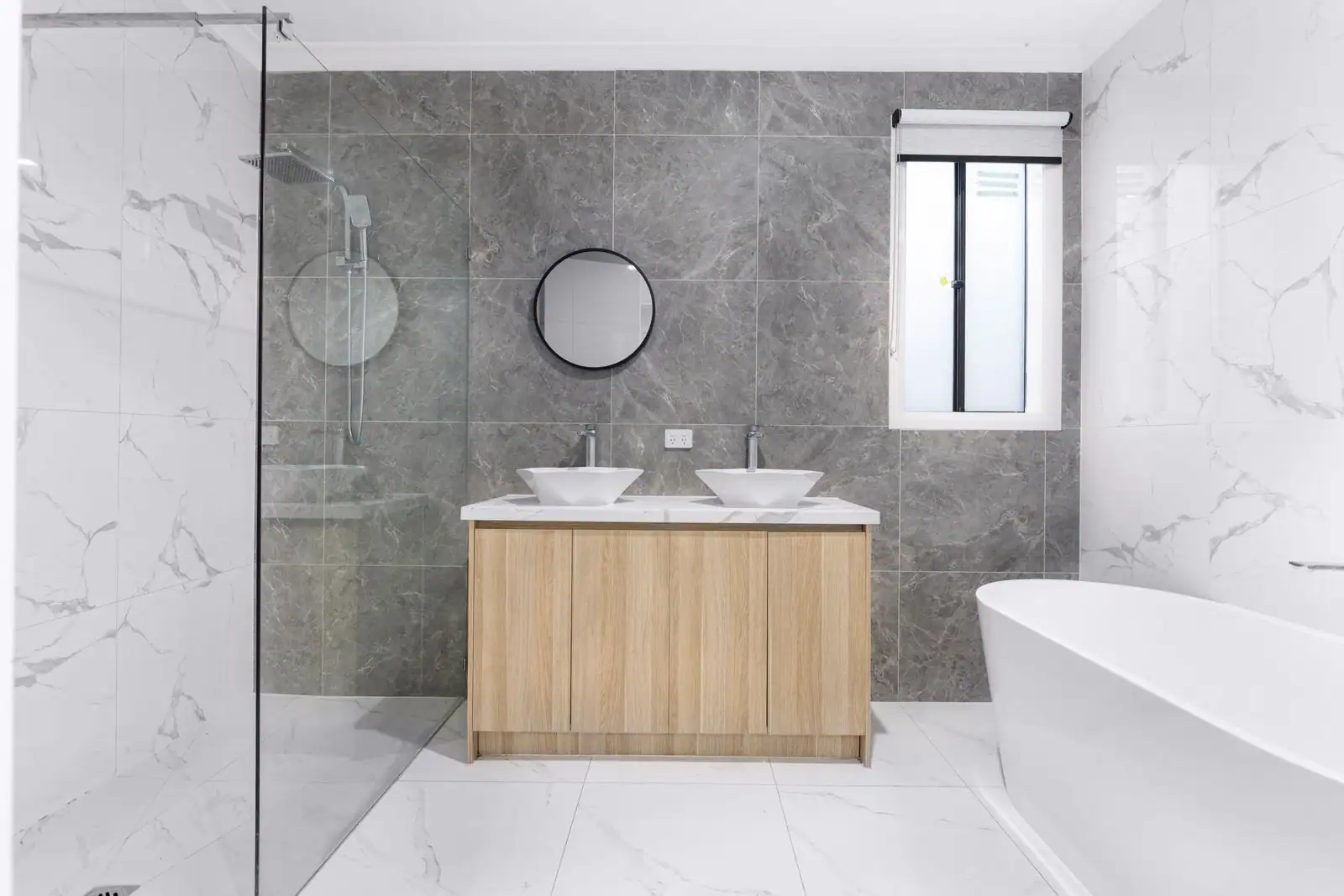 Salle de bain moderne rénovée avec douche à l'italienne, double vasque bois et carrelage effet marbre