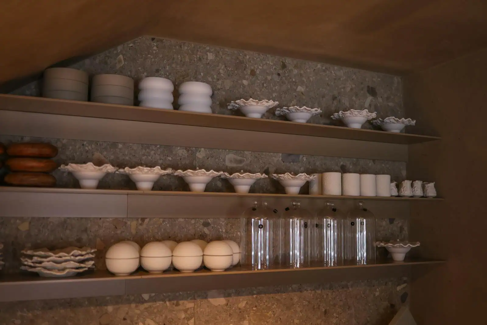 Vaisselle blanche et verres rangés sur des étagères de cuisine