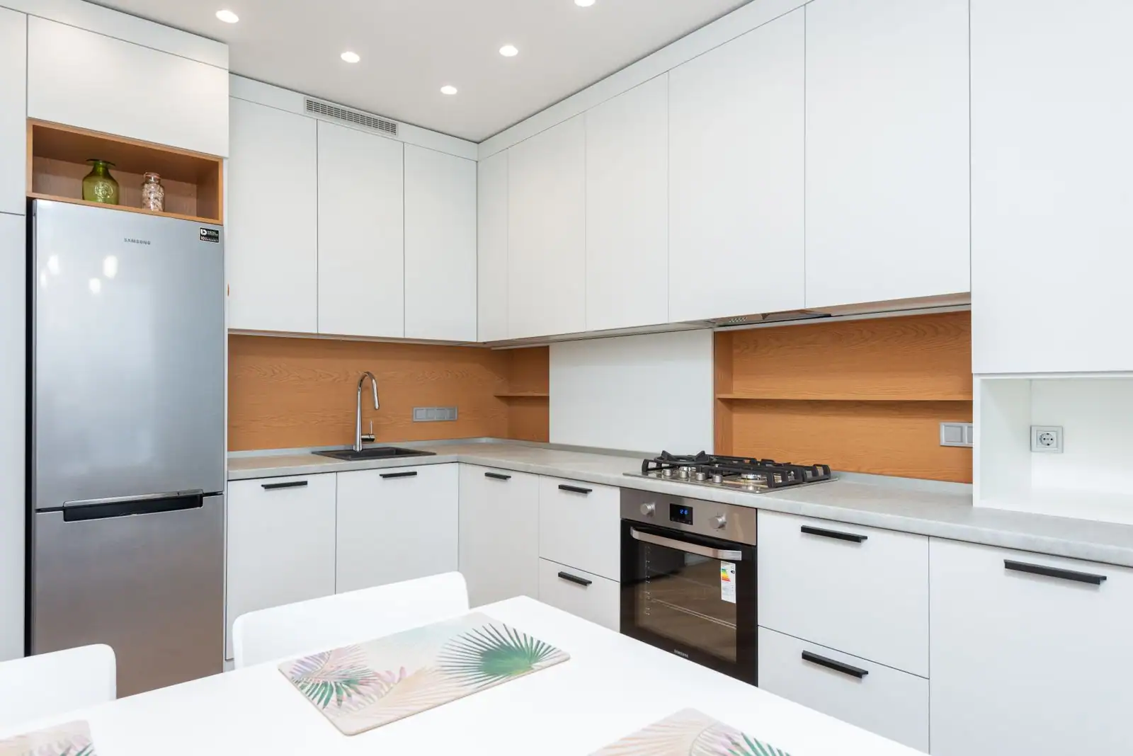 Réfrigérateur congélateur installé dans une colonne de meubles d'une cuisine équipée, façade inox visible