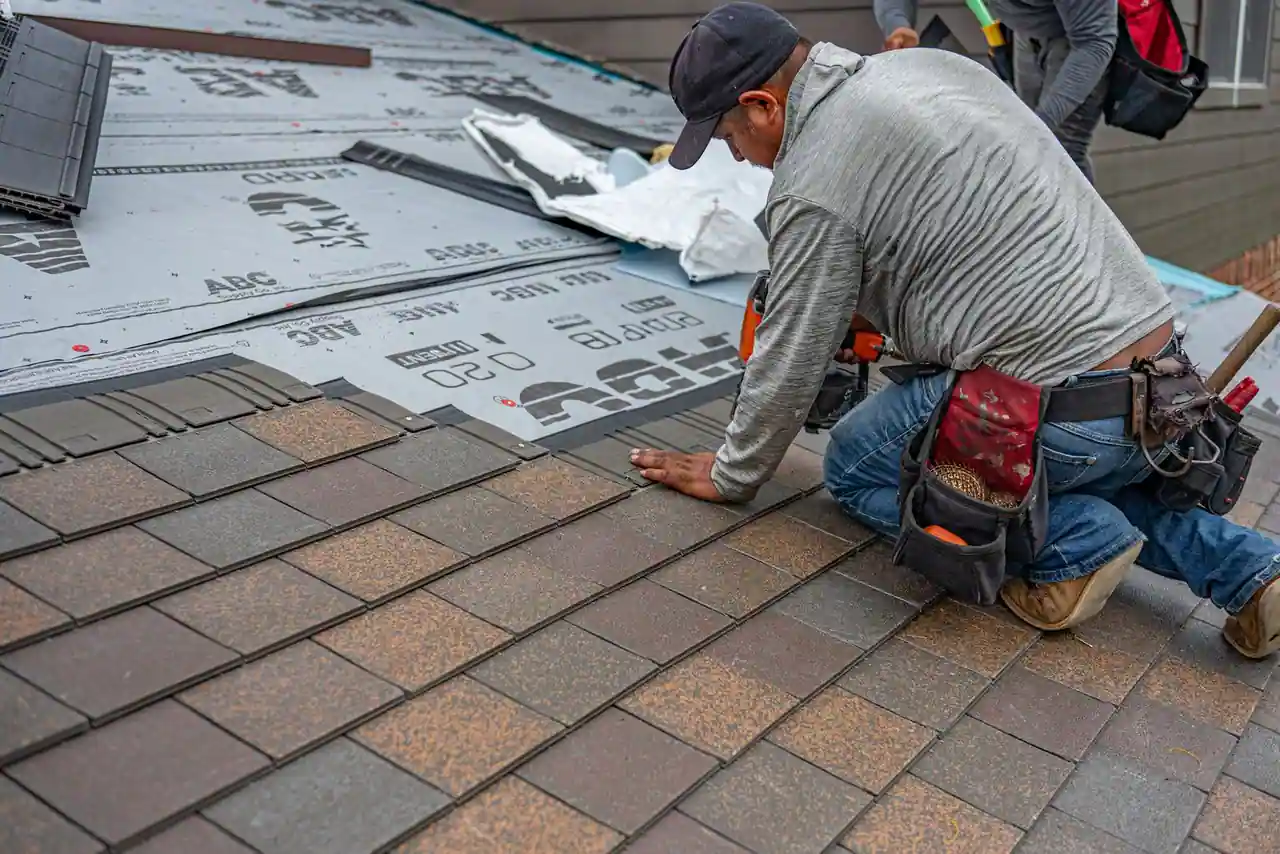 Couvreur posant des tuiles lors de la rénovation d'une toiture résidentielle