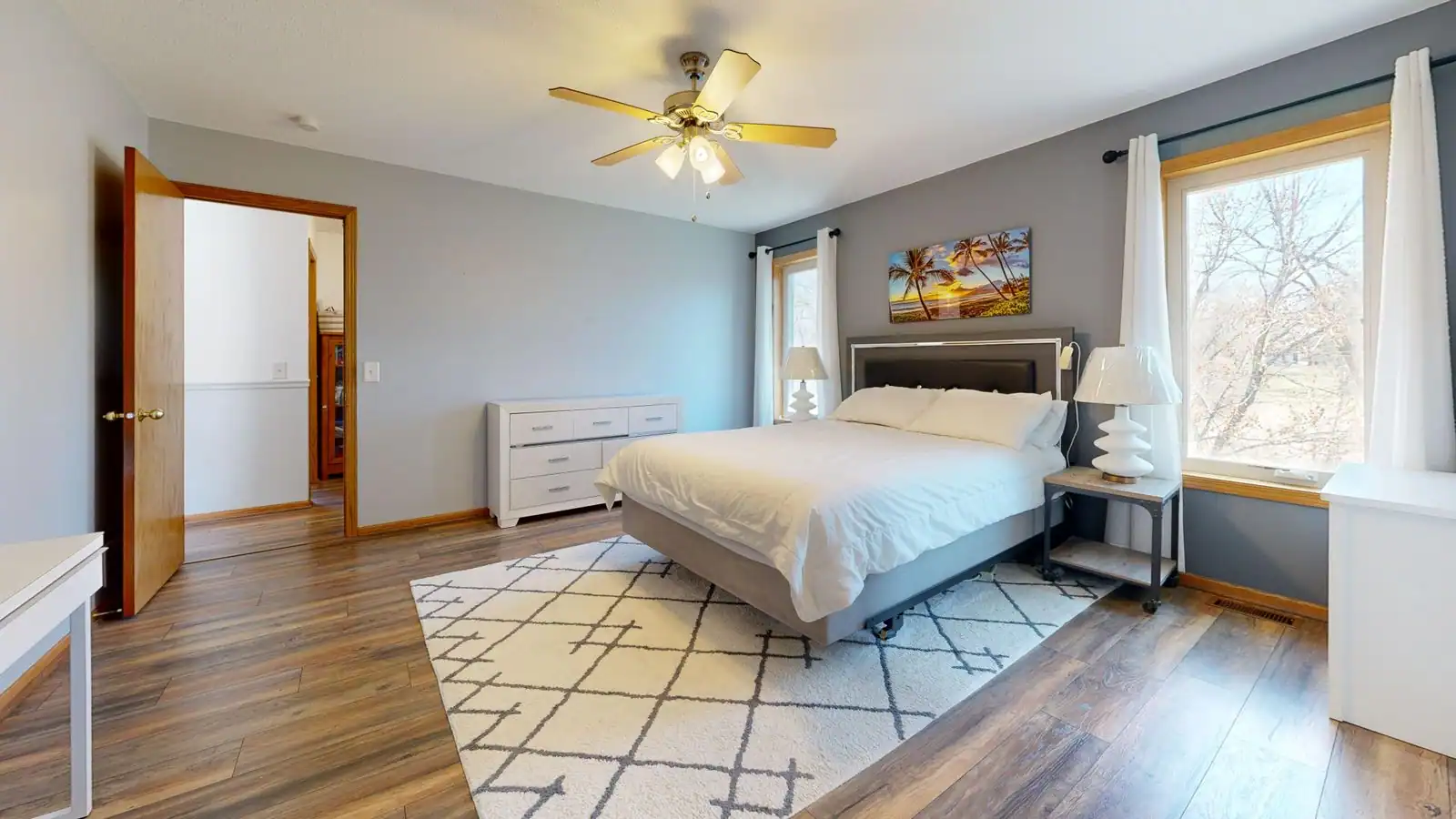Tapis posé au sol dans une chambre moderne au pied d'un lit, illustrant le choix d'un tapis de chambre