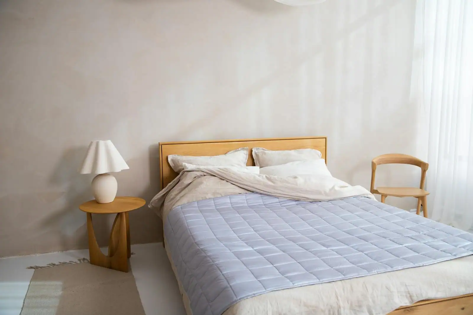 Chambre à coucher aux tons neutres et chauds avec tête de lit en bois et linge de lit naturel