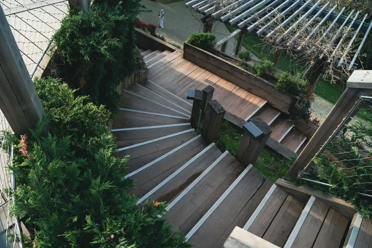 Terrasse en bois exotique aux lames denses et chaudes, posée dans un jardin extérieur ensoleillé