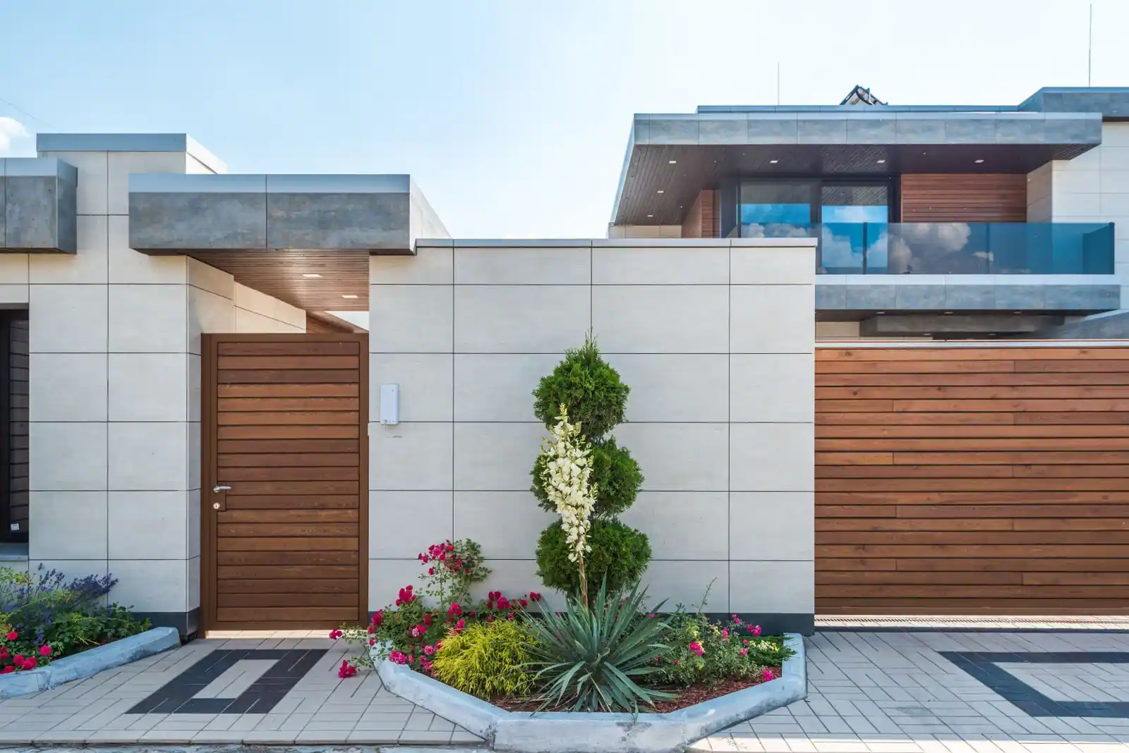 Façade d'une maison individuelle avec jardin et allée d'entrée, sous une lumière douce de journée.