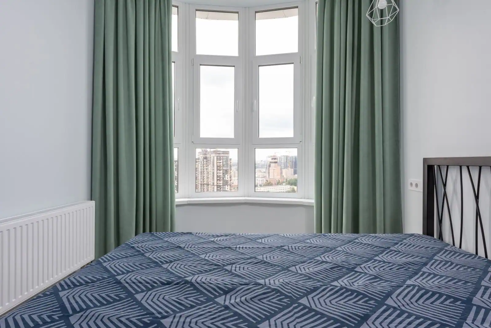Chambre lumineuse ouverte sur une grande fenêtre avec vue sur un paysage