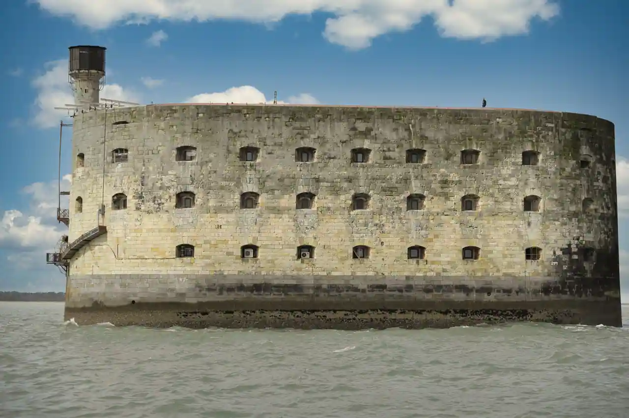 Le fort Boyard vu depuis la mer : sa muraille de pierre ovale posée sur un socle maçonné.
