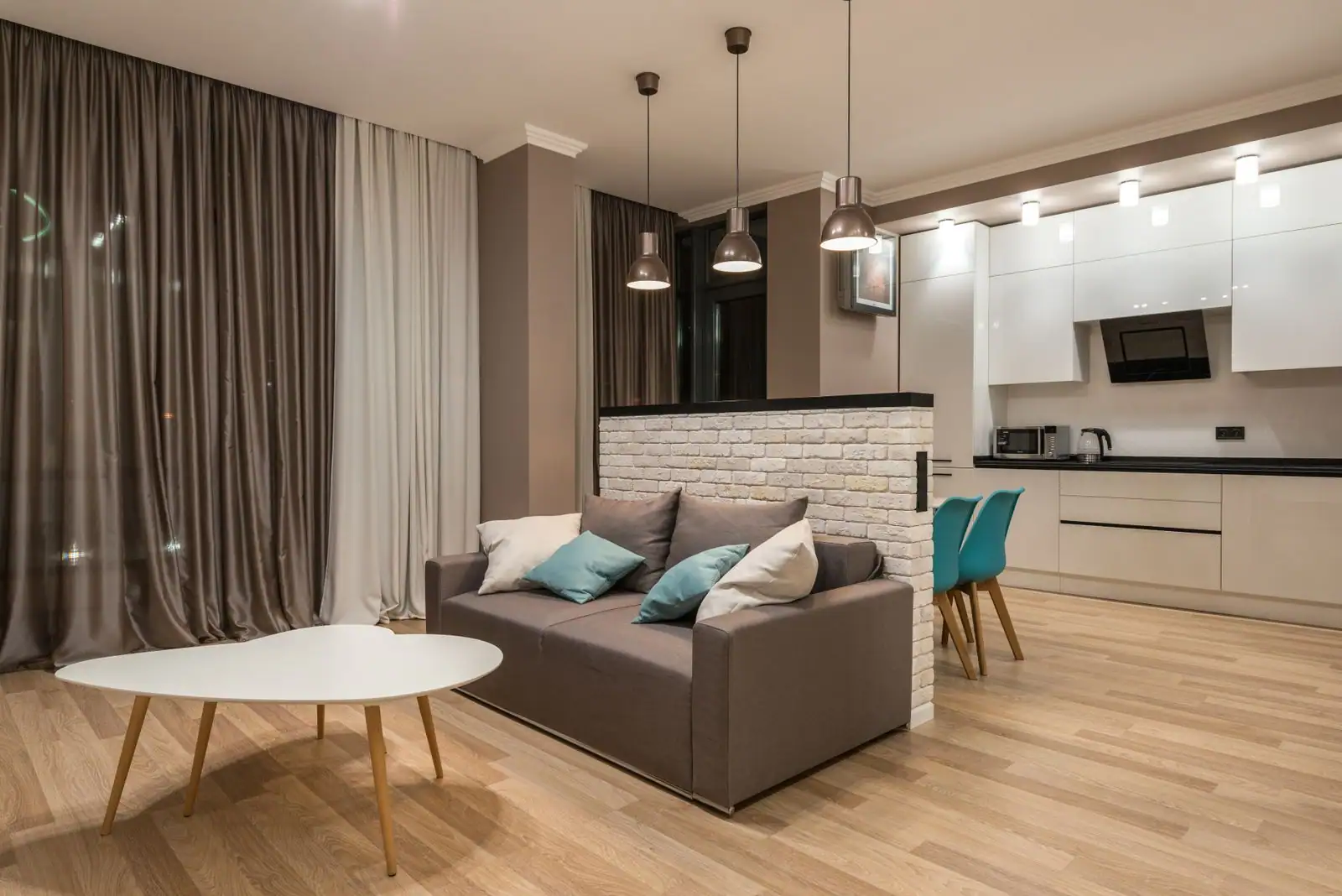 Séjour lumineux d'un appartement meublé ouvert sur une cuisine, prêt à la mise en location.