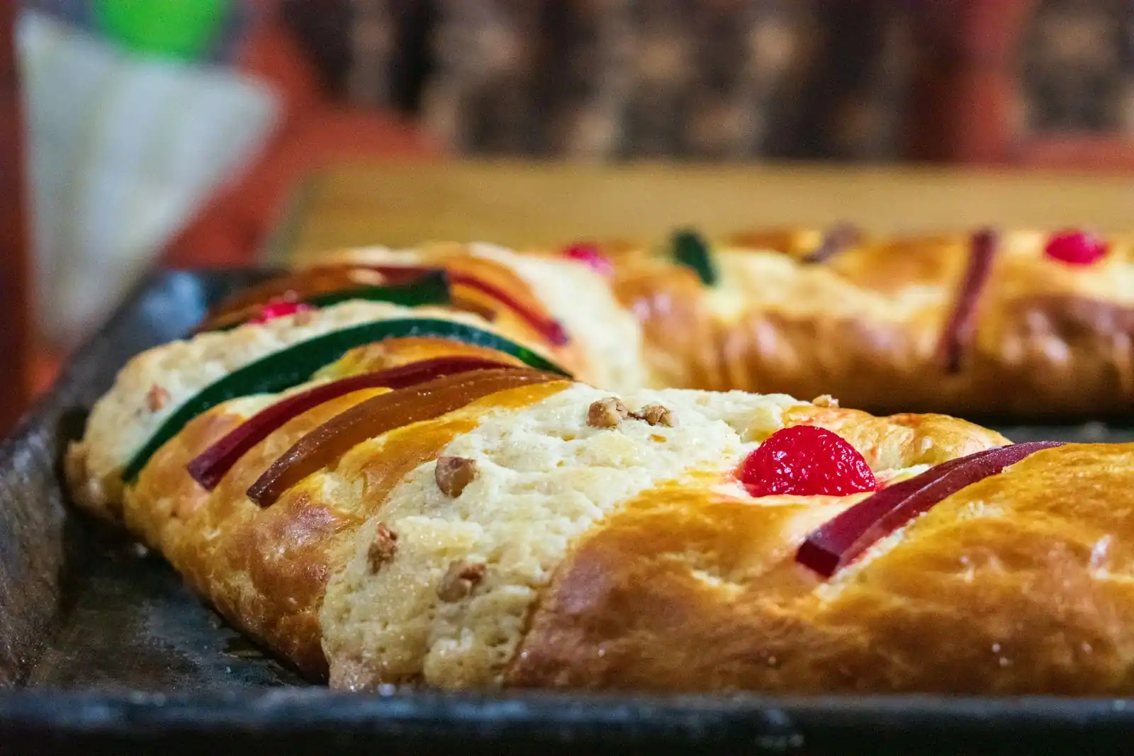 Gâteau des rois brioché décoré de fruits confits rouges et verts, servi pour l'Épiphanie