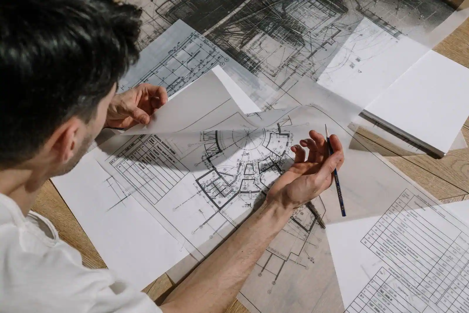 Plans d'architecte et tirage de construction d'une maison, étalés sur un plan de travail