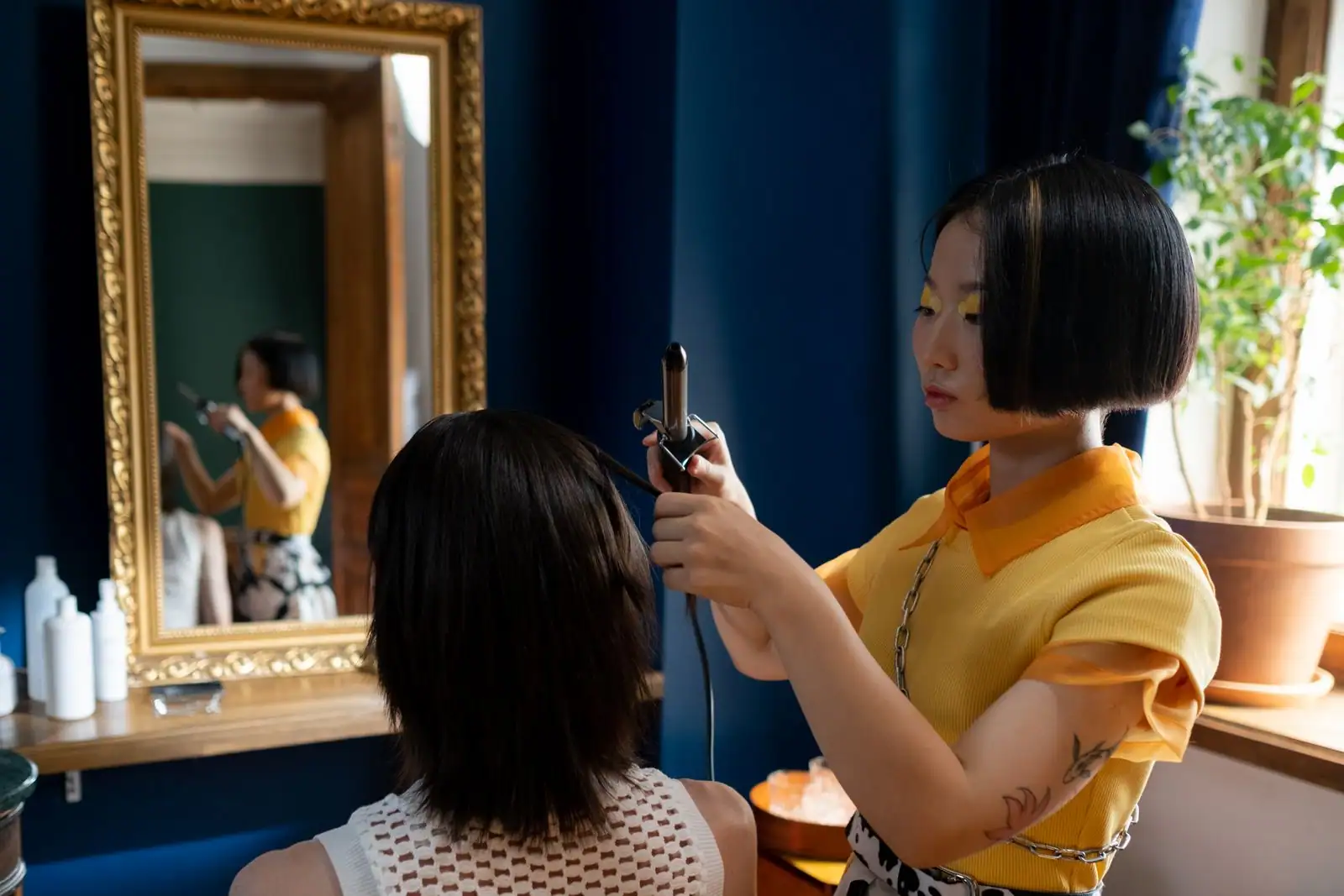 Coiffeuse en train de coiffer une cliente dans un salon de coiffure lumineux