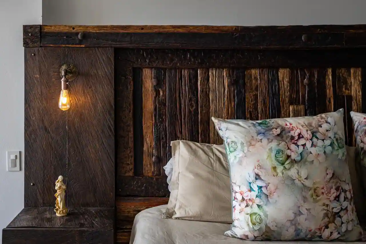 Chambre décorée dans un style chaleureux, tête de lit en bois clair et linge de lit en lin naturel.